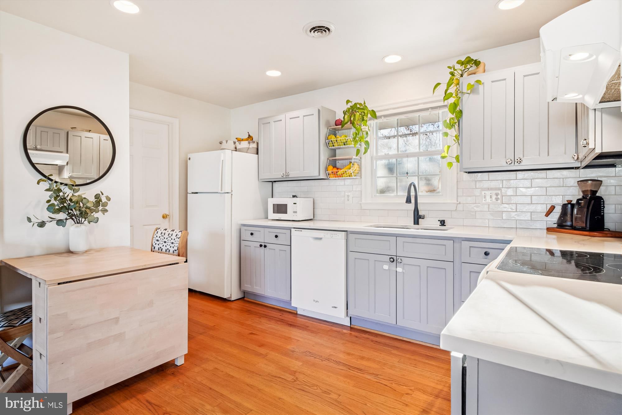 3064 Centre Road Riva, MD 21140 - Photo 11 of 45 a kitchen with a sink dishwasher a stove a dining table and chairs with wooden floor