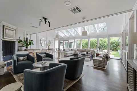 a living room with fireplace furniture and a large window
