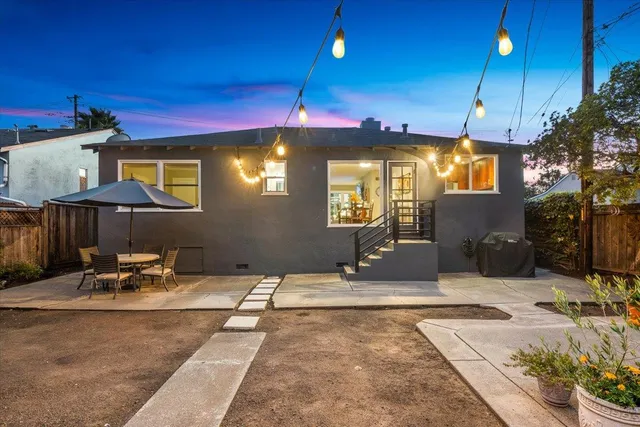 a backyard of a house with table and chairs