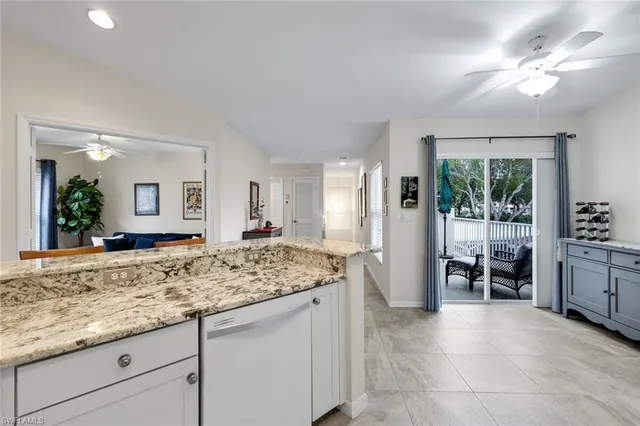 a kitchen with stainless steel appliances kitchen island granite countertop a refrigerator a stove a microwave oven a dining table and chairs with wooden floor