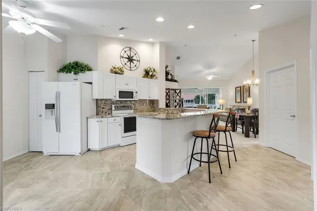 a large white kitchen with a large window