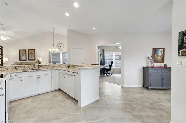 a room with chandelier fan and windows