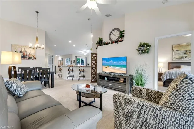 a living room with furniture kitchen view and a chandelier