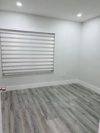 a view of a room with wooden floor and a window