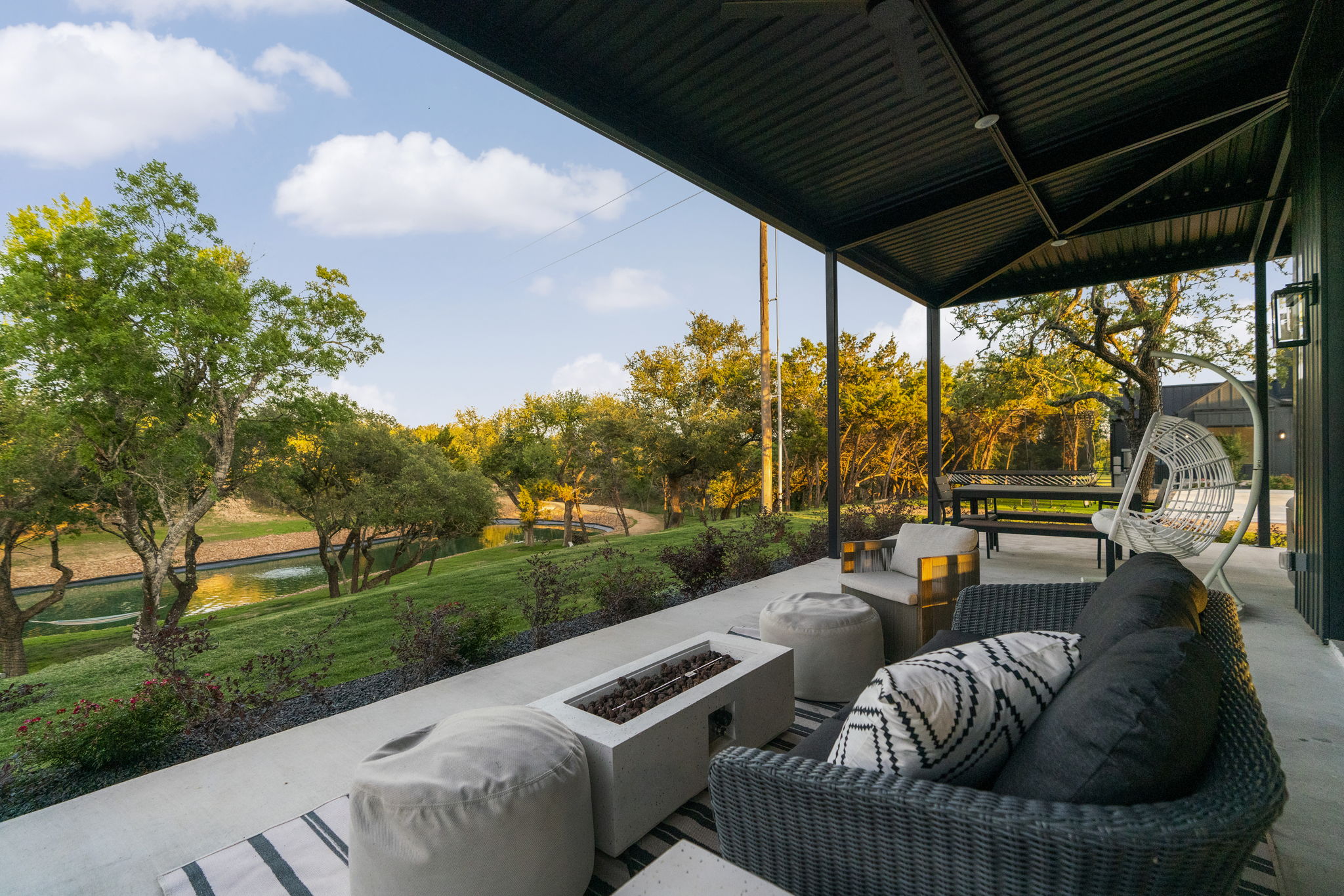 475 Happy Trail Dripping Springs, TX 78620 - Photo 31 of 40 Relax on the expansive wrap around patio off of the party barn. With views of the pond and property beyond it's an amazing spot to unwind.