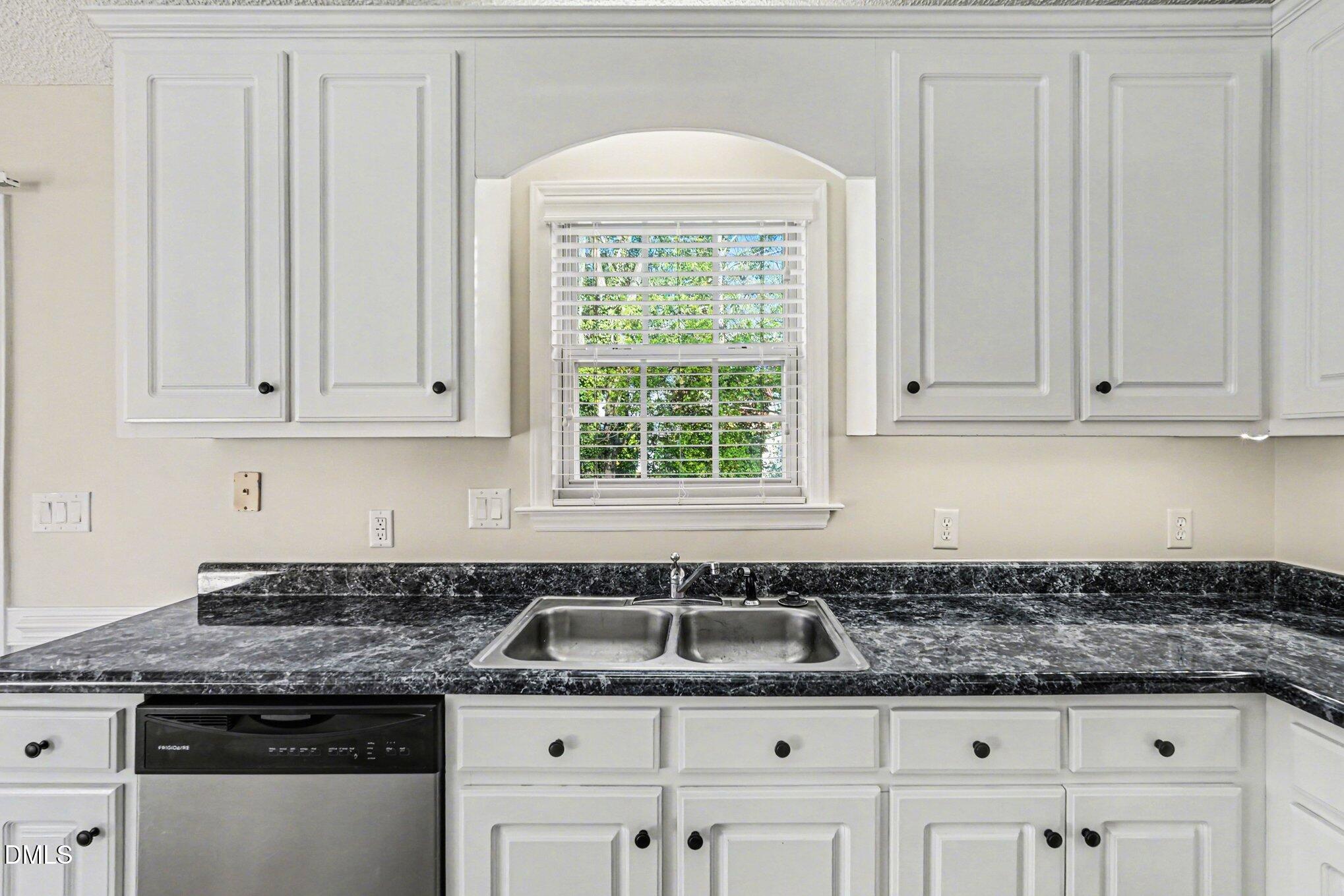 284 Dullis Circle Garner, NC 27529 - Photo 11 of 35 a kitchen with granite countertop a sink a stove and cabinets