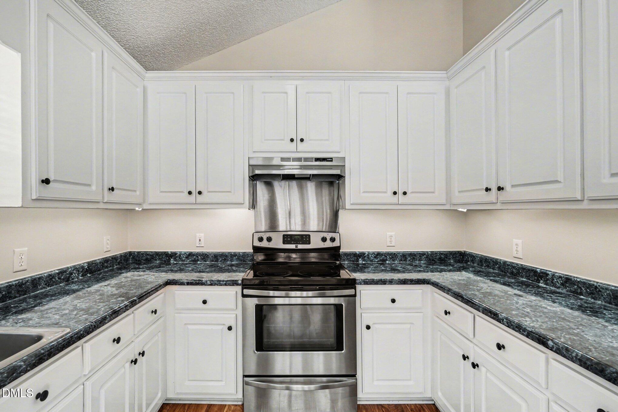 284 Dullis Circle Garner, NC 27529 - Photo 13 of 35 a kitchen with granite countertop white cabinets and stainless steel appliances