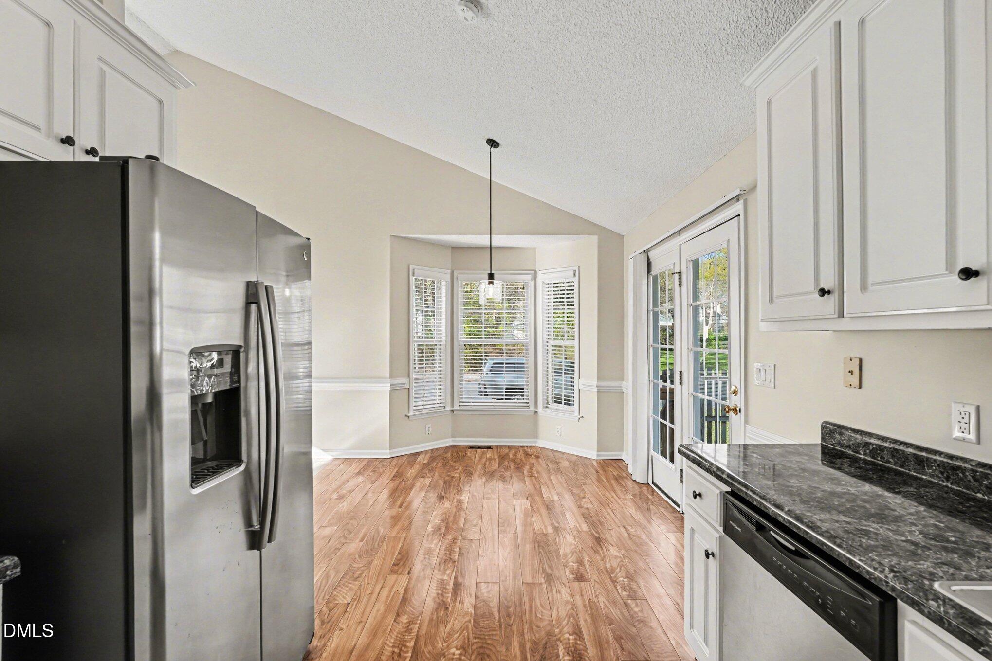 284 Dullis Circle Garner, NC 27529 - Photo 14 of 35 a kitchen with stainless steel appliances granite countertop a refrigerator and a stove top oven