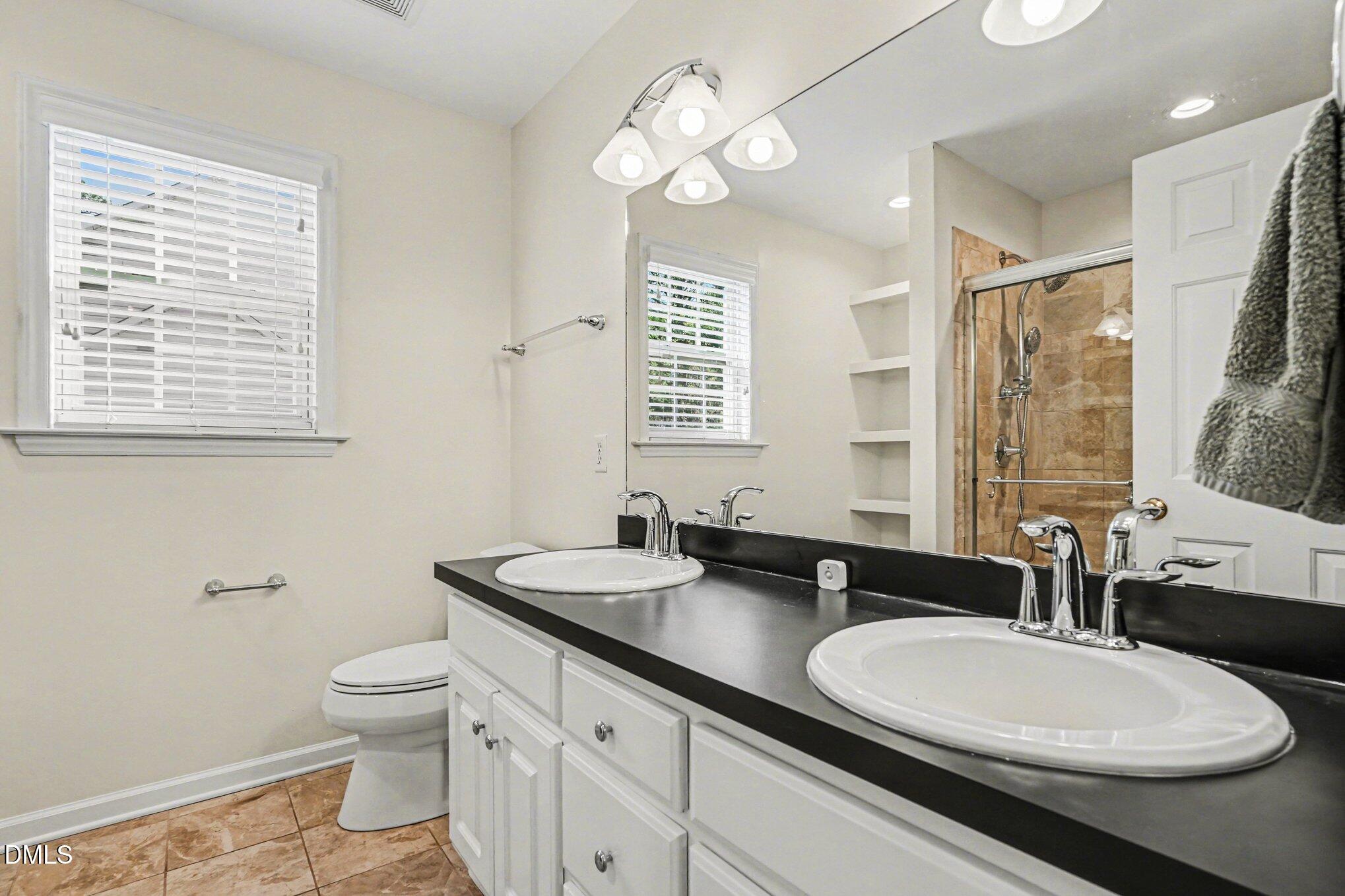 284 Dullis Circle Garner, NC 27529 - Photo 26 of 35 a bathroom with a double vanity sink toilet and a mirror