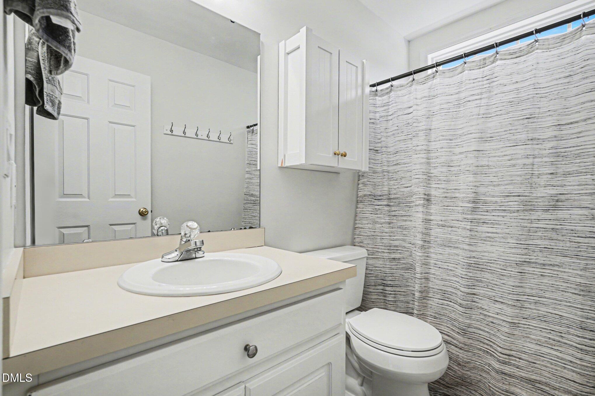 284 Dullis Circle Garner, NC 27529 - Photo 27 of 35 a bathroom with a sink a toilet and shower curtain