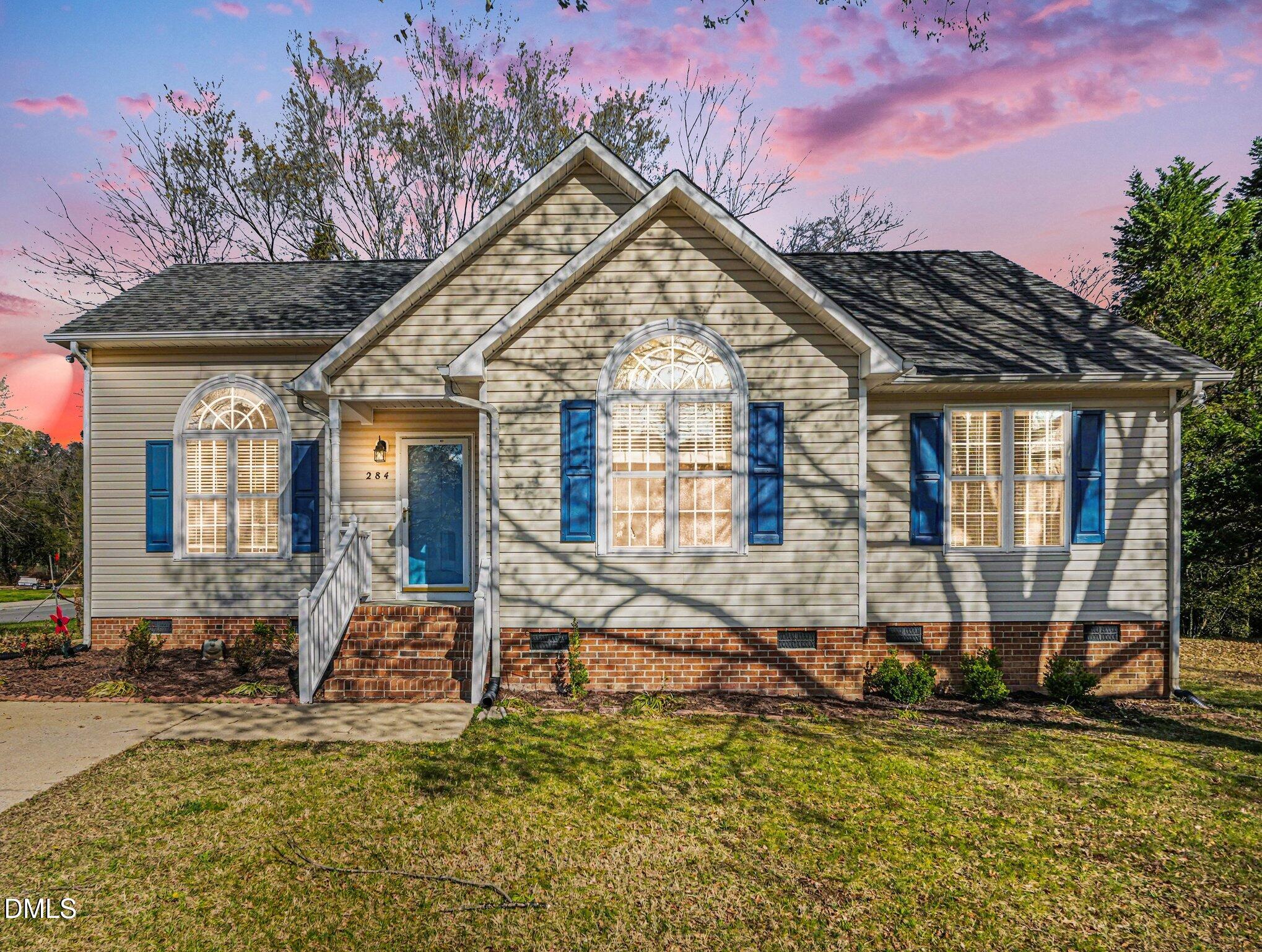 284 Dullis Circle Garner, NC 27529 - Photo 6 of 35 a view of a house with large windows and a yard