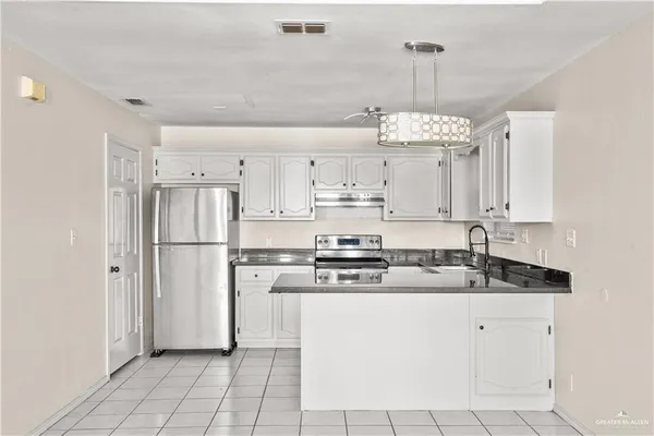 a kitchen with kitchen island granite countertop cabinets and stainless steel appliances