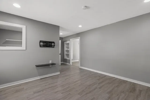 a view of empty room with wooden floor