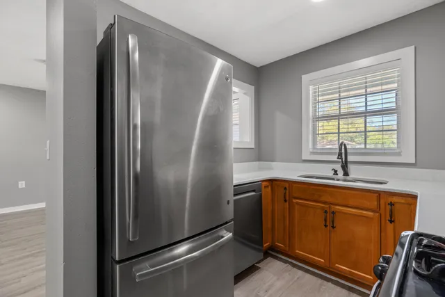 a kitchen with stainless steel appliances granite countertop a refrigerator and a sink