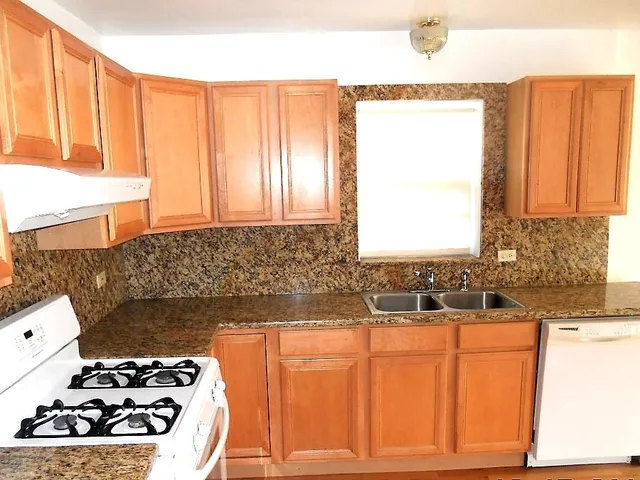 a kitchen with a sink a stove and a window