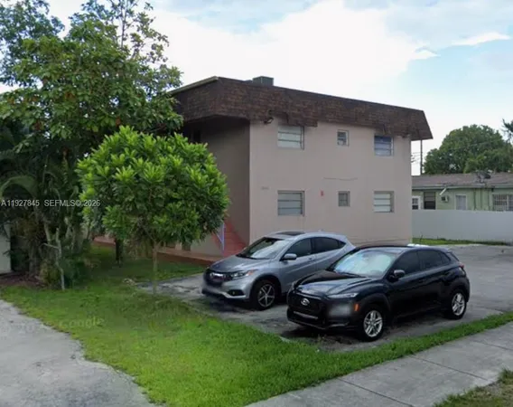a car parked in front of a house with a garden