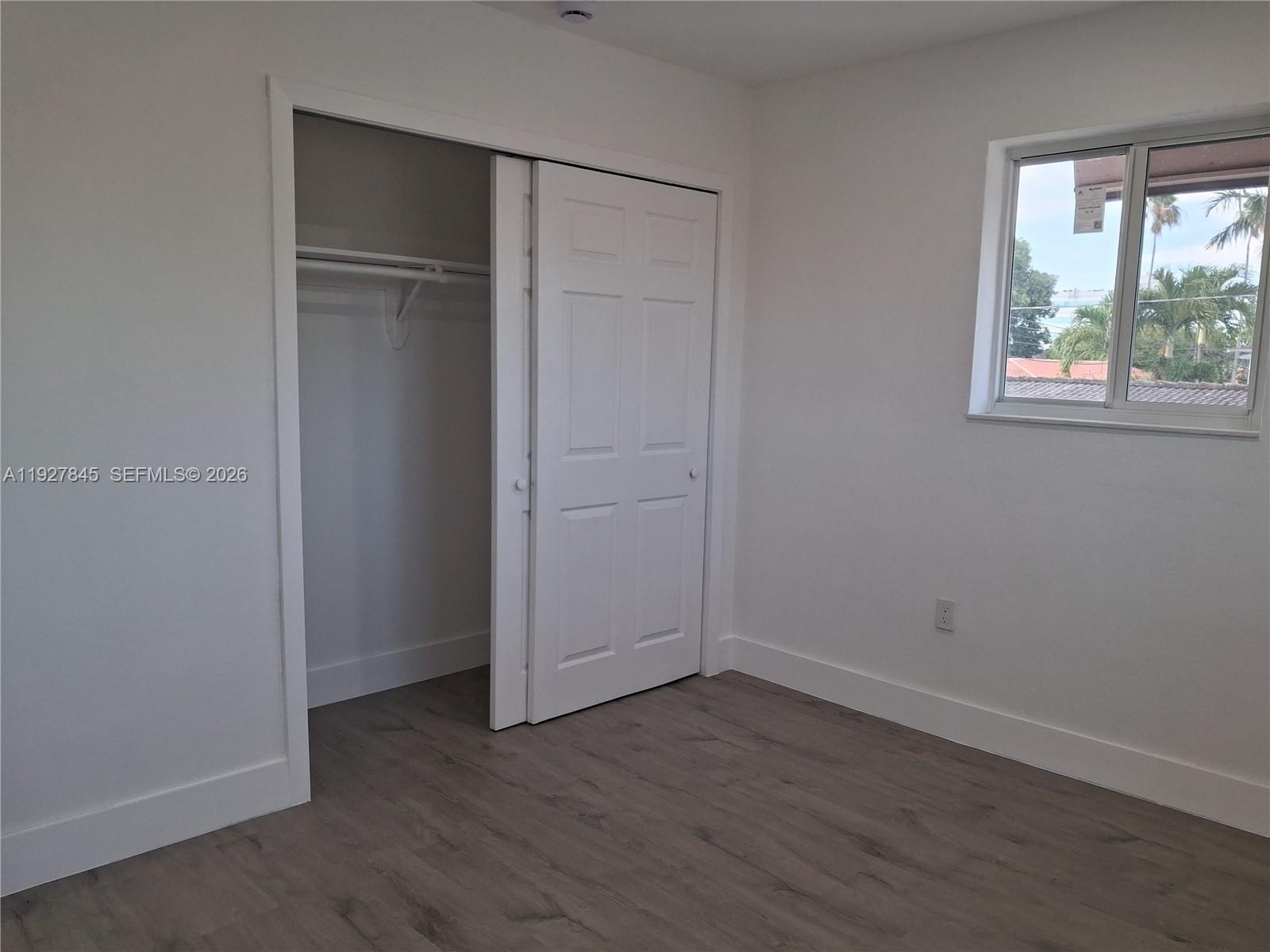 2155 Southwest 72nd Avenue Miami, FL 33155 - Photo 6 of 11 an empty room with wooden floor closet and windows