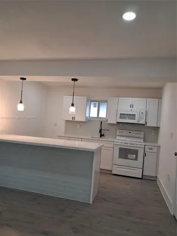 a kitchen with cabinets appliances and a counter space