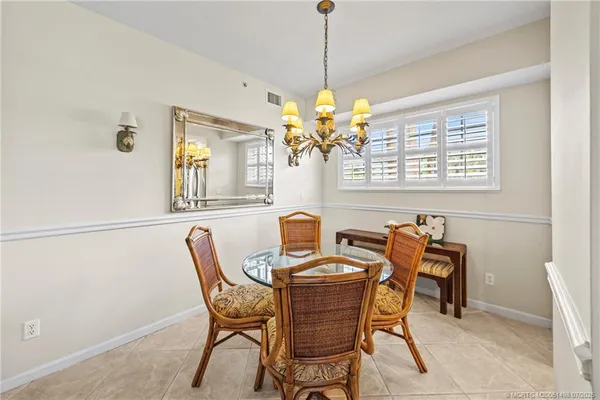 a dining room filled chandelier and kitchen view