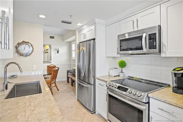a kitchen with stainless steel appliances a sink and a refrigerator