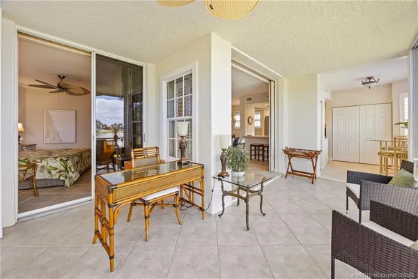 a view of a dining room with furniture water view and a floor to ceiling window
