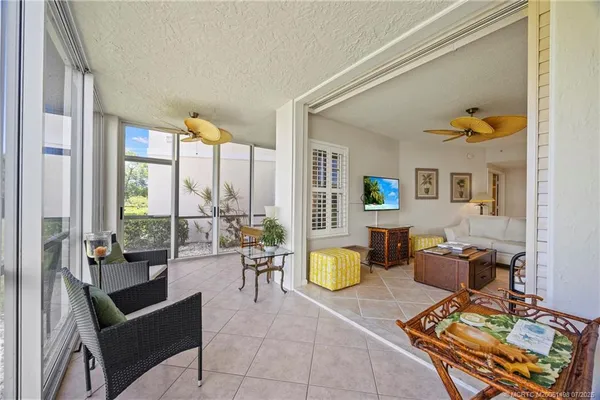 a living room with furniture and floor to ceiling windows