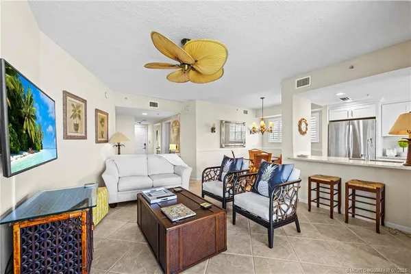 a living room with furniture a flat screen tv and a large window