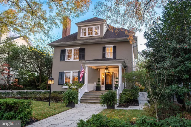 a front view of a house with a yard and potted plants