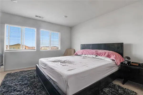 a bed sitting in a bedroom next to a window