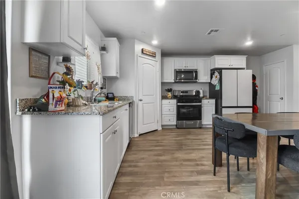 a kitchen with white cabinets and stainless steel appliances