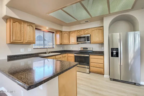 a kitchen with stainless steel appliances granite countertop a stove a sink and a microwave