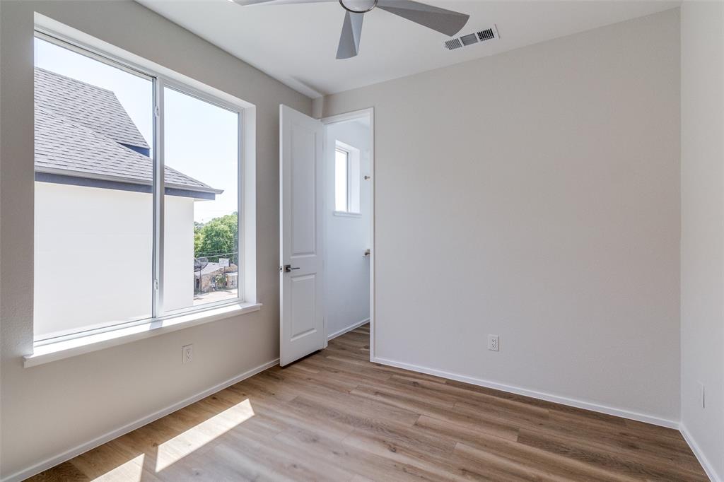 3308 Birmingham Avenue, Unit A1 Dallas, TX 75210 - Photo 22 of 33 an empty room with wooden floor and windows