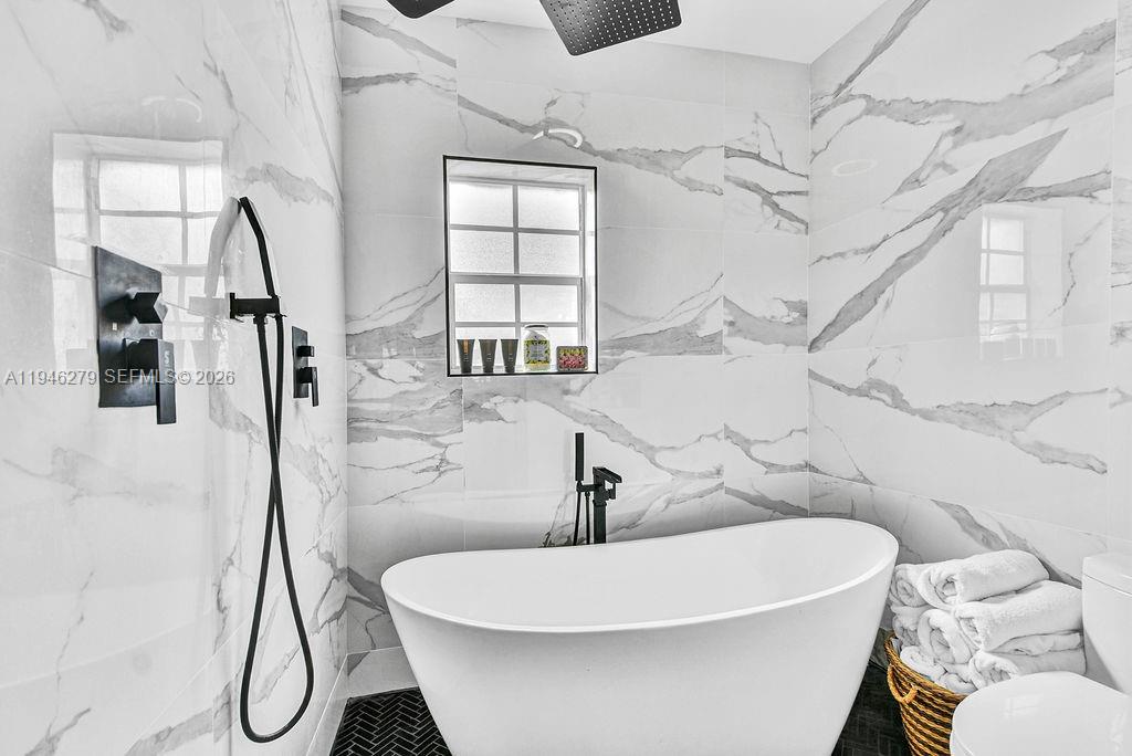 4722 Southwest 5th Street Miami, FL 33134 - Photo 9 of 18 a white bath tub sitting next to a white sink and glass door