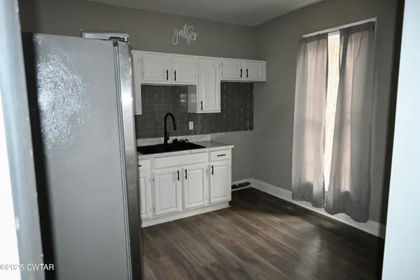 a kitchen with a refrigerator a sink and cabinets