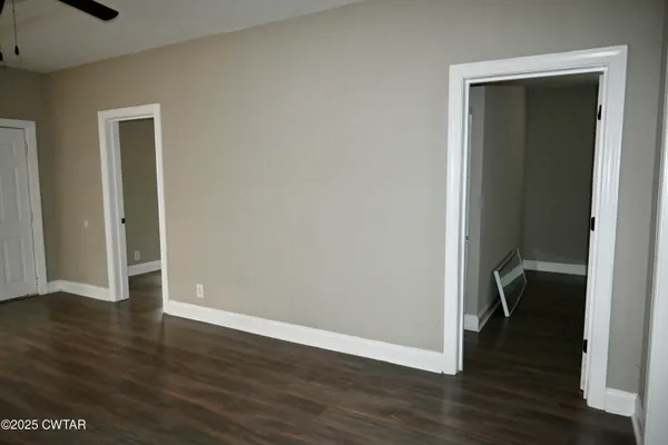 an empty room with wooden floor & closet