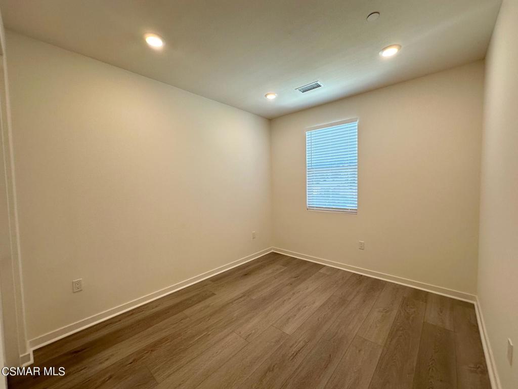 10726 Telegraph Road Ventura, CA 93004 - Photo 14 of 25 an empty room with wooden floor and windows