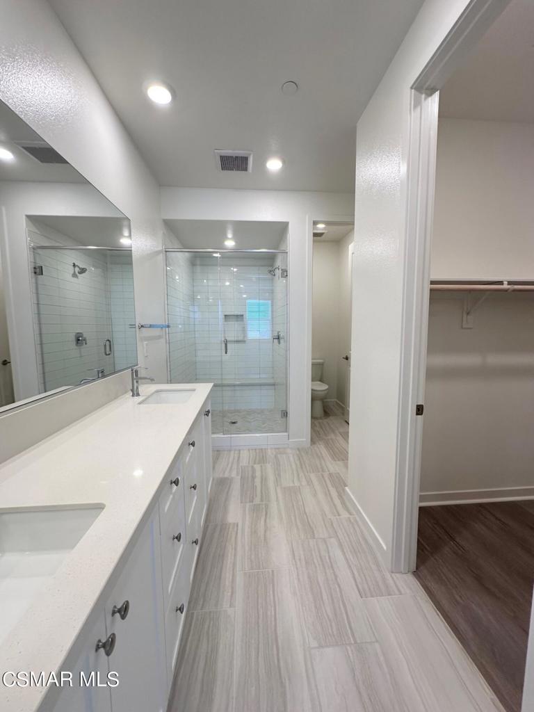 10726 Telegraph Road Ventura, CA 93004 - Photo 9 of 25 a spacious bathroom with a granite countertop sink a toilet a shower and a mirror