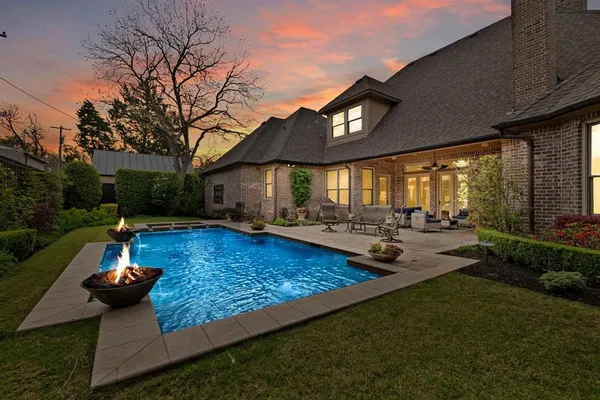 a view of a house with backyard swimming pool and sitting area