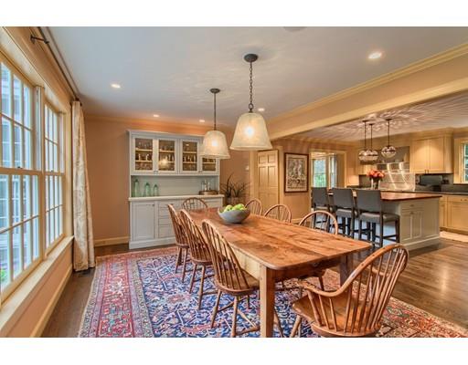 37 Garland Road Concord, MA 01742 - Photo 13 of 33 a view of a dining room and livingroom with furniture wooden floor a rug a flat screen tv a painting and a chandelier