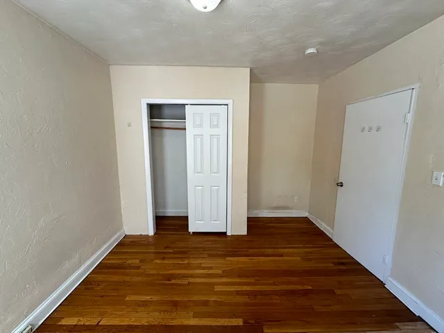 an empty room with wooden floor and closet