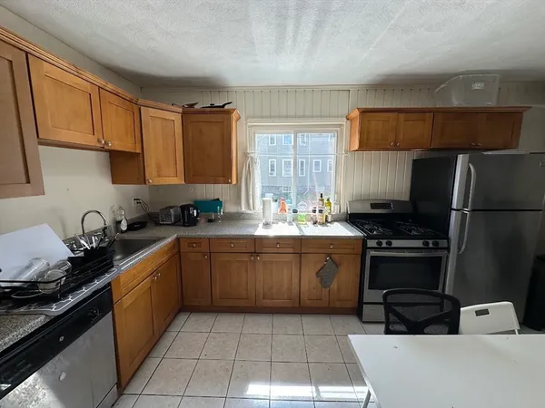 a kitchen with stainless steel appliances granite countertop a sink stove refrigerator and cabinets