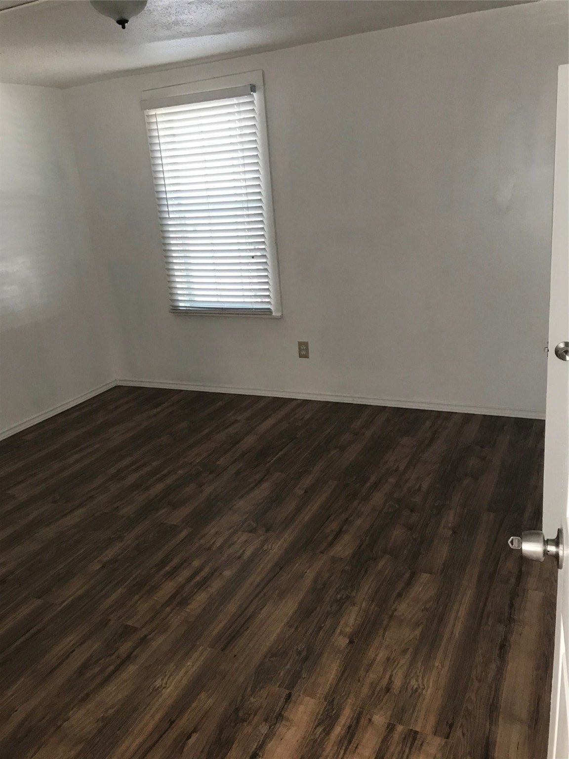 2909 Sam Houston Avenue Huntsville, TX 77340 - Photo 12 of 16 an empty room with wooden floor and windows