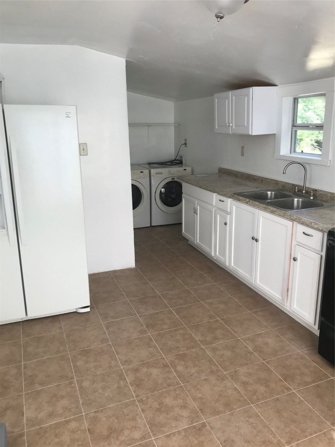 2909 Sam Houston Avenue Huntsville, TX 77340 - Photo 13 of 16 a kitchen with a sink a stove and refrigerator