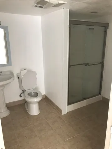 a white toilet sitting next to a bathroom sink