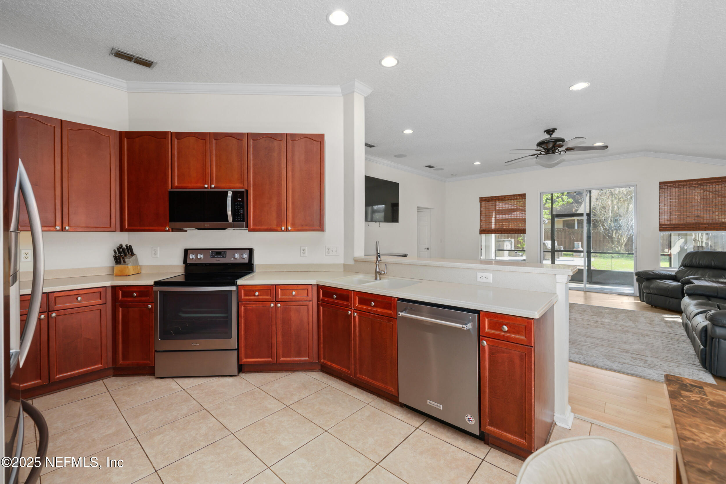 1256 Splendid Ravine Street St. Augustine, FL 32092 - Photo 8 of 36 a kitchen with stainless steel appliances granite countertop a stove top oven a sink dishwasher a dining table and chairs with wooden floor