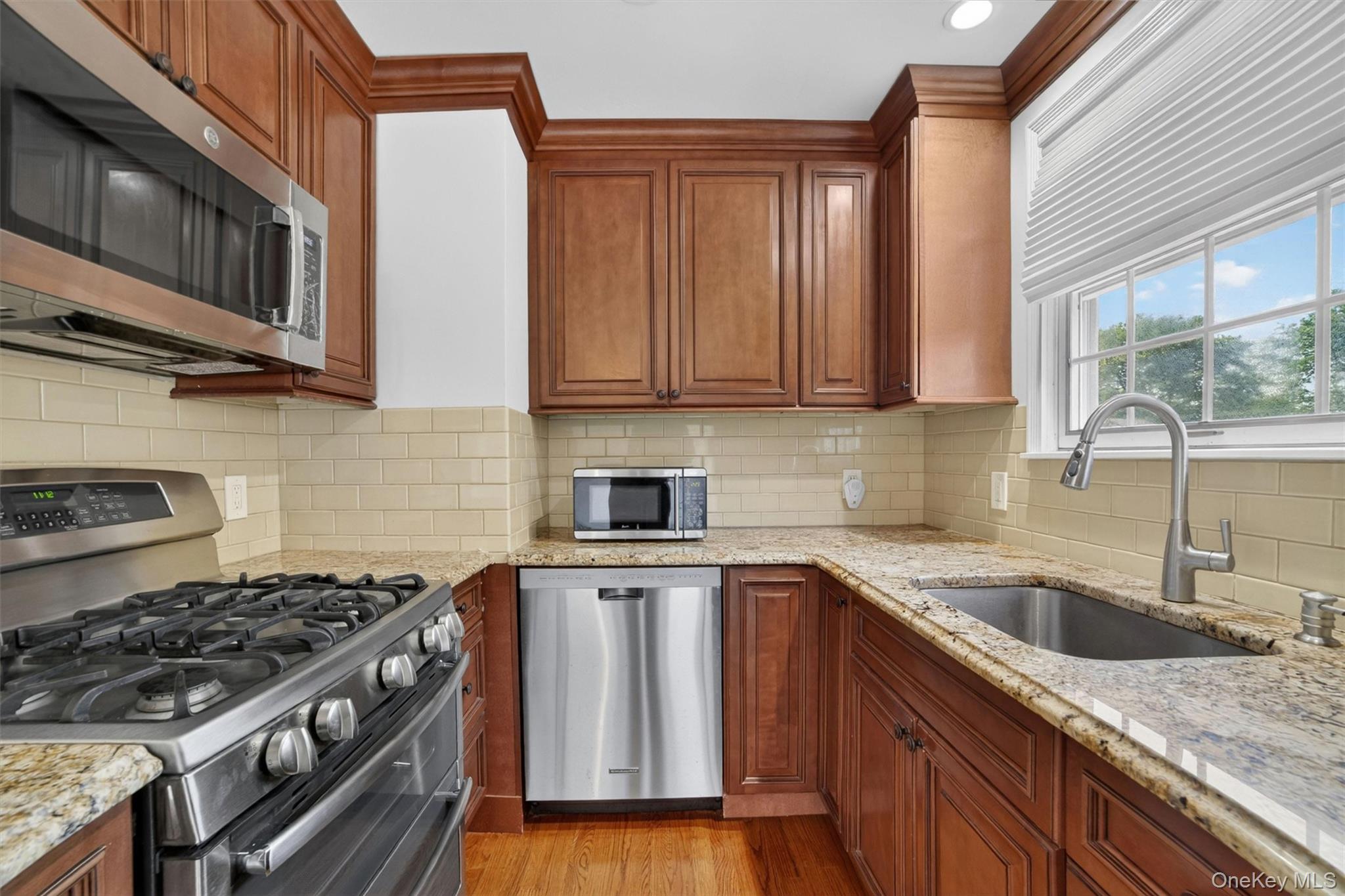 263 Croydon Road Yonkers, NY 10710 - Photo 10 of 43 a kitchen with granite countertop a sink stove and cabinets