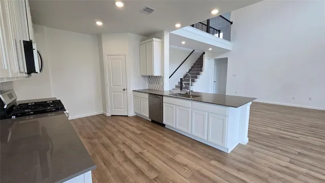 a kitchen with white cabinets and stainless steel appliances