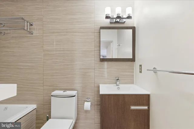 a bathroom with a toilet sink and mirror