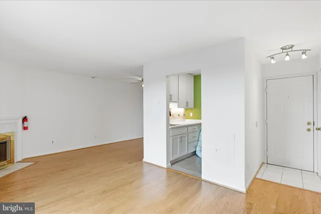 an empty room with wooden floor and cabinet