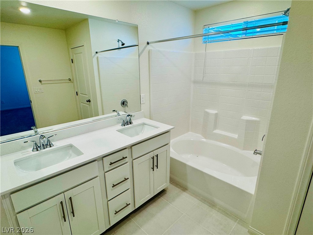 9249 Innot Avenue Las Vegas, NV 89148 - Photo 16 of 24 A well-appointed bathroom offers a dual vanity and a pristine shower-over-tub combination.